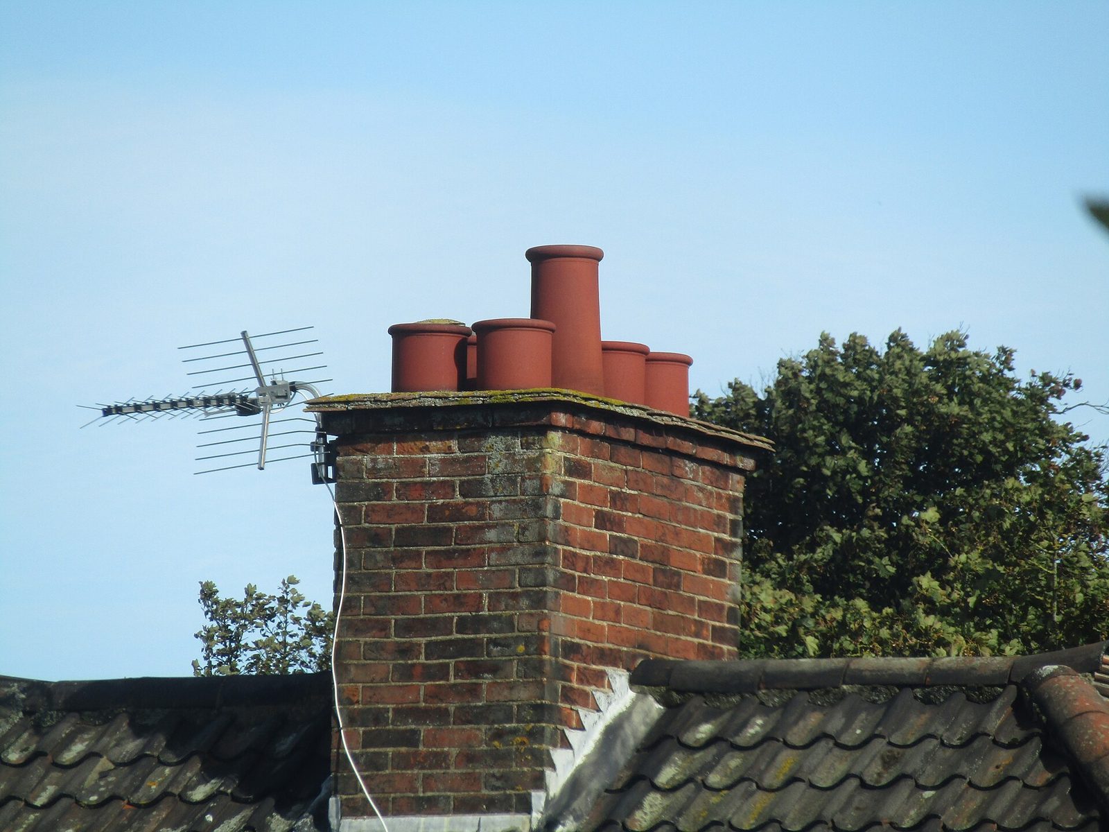 Brick chimney with clay pots and TV aerial