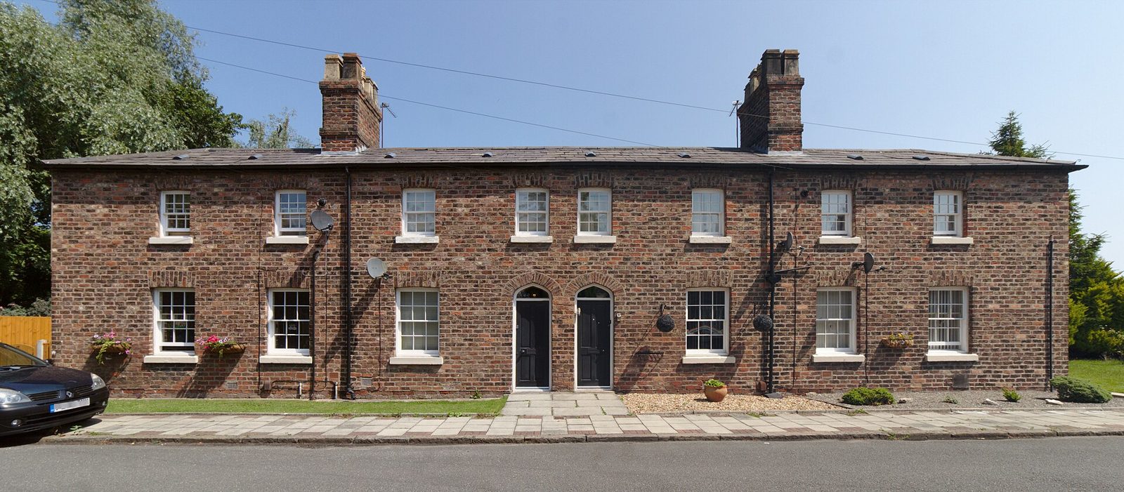 Row of traditional English red-brick terraced houses with slate roofs