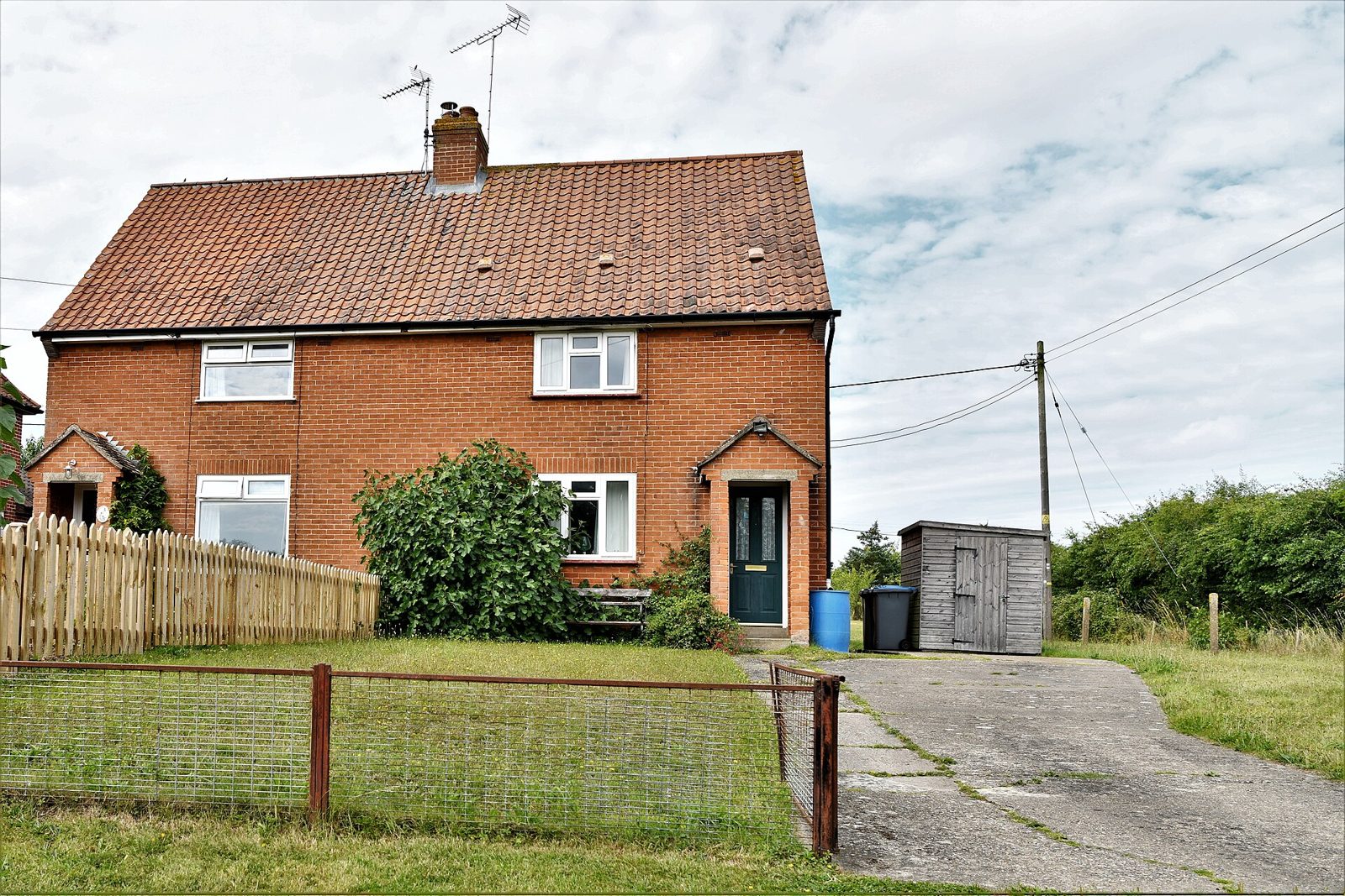 Red-brick semi-detached house with clay tiled roof and chimney